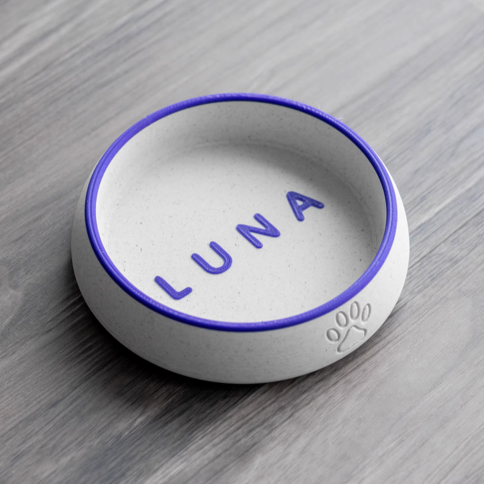 White PLA pet bowl with blue-violet rim and engraved name “LUNA”