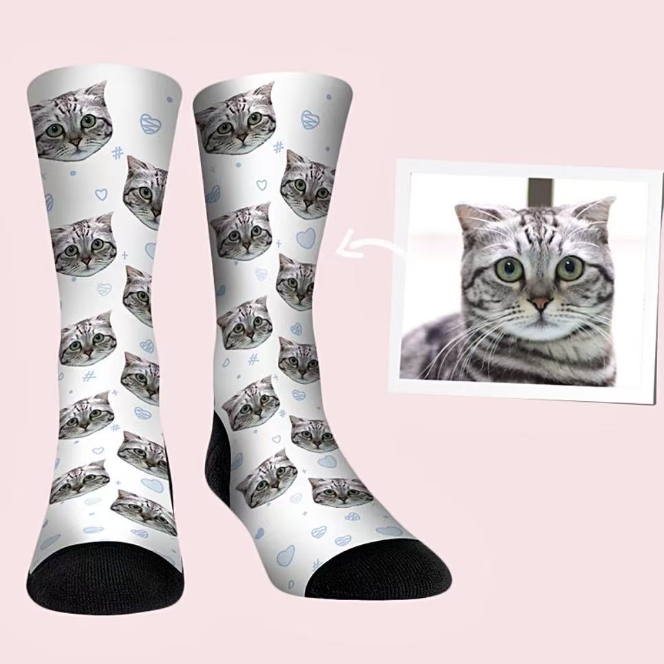 Custom pet face socks featuring a gray tabby cat with blue heart and doodle pattern background