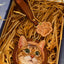 Custom leather portrait charm of a tabby cat with green eyes, packed in gift box with matching brown paw tag and leather strap