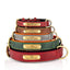 Stack of engraved PU leather pet collars in red, brown, gray, green, and black with brass nameplates.
