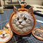 Handmade realistic leather hanging charm featuring a grey Maine Coon cat, carved and painted in 3D detail, shown on workbench with tools