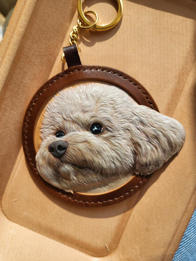 Hand-carved 3D leather portrait of a white poodle-style dog with gold keyring, ultra-realistic texture made from genuine cowhide leather
