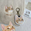 Personalized embroidered cat keychain with metal clasp, shown alongside real cat and fabric embroidery.