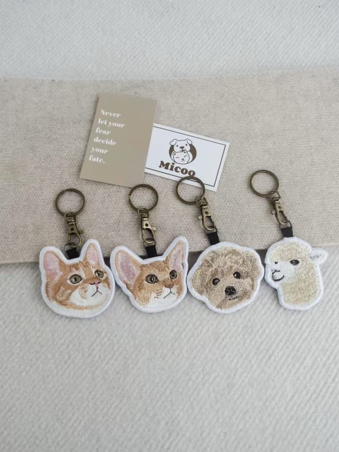 Embroidered keychain of a custom cat and dog portrait with clasp, made from uploaded pet photo.
