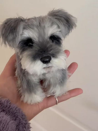 Twist yarn stick of a miniature schnauzer with gray and white fur, shown on palm