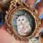 Oval brown ceramic fridge magnet with oil painting-style cat portrait