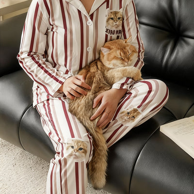 Owner wearing blue dotted custom pajamas printed with her black poodle’s face while holding the dog