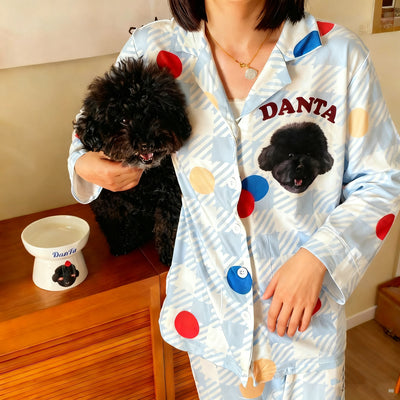Woman wearing personalized striped pajamas featuring her brown dog’s face while holding the same dog in matching outfit