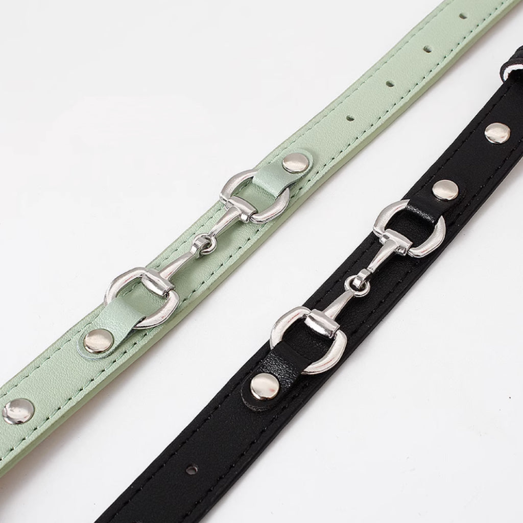Side by side close up of mint green and black horsebit style dog collars