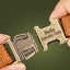 Close-up of engraved metal buckle with pet name and phone number on dog harness.