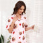 Model wearing pink short-sleeve dog print pajamas holding a cup