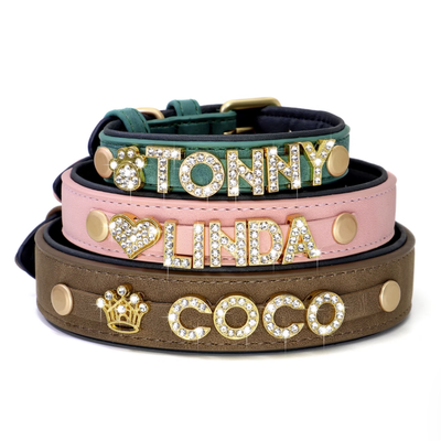 Three stacked rhinestone pet collars in green, pink, and brown showing custom names.