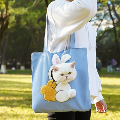 Blue tote bag with bunny tail and ears, cat’s head peeking through